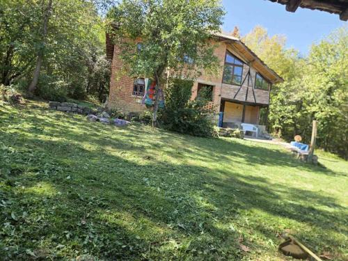 a person sitting on a bench in front of a house at Balkan Mountains Villa Spa in Elena