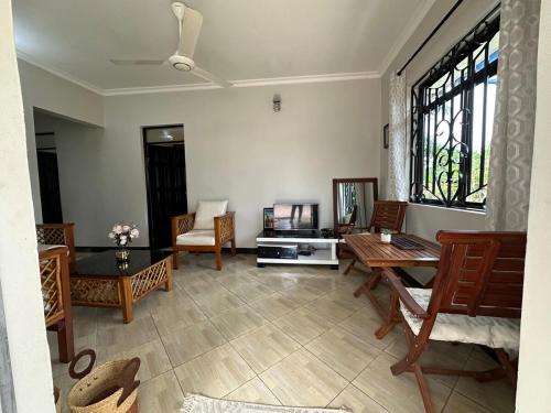 een woonkamer met een tafel en stoelen bij Apartment 72 in Moshi