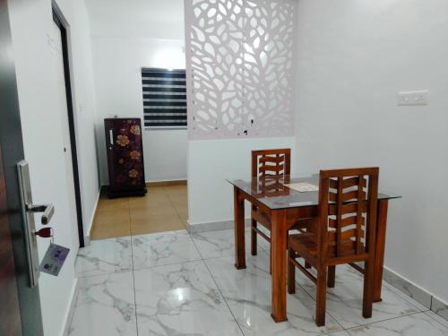 a dining room with a table and two chairs at The Mountmist Apartment in Cochin