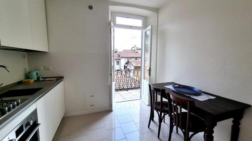 a kitchen with a table with chairs and a window at Piazza Vecchia Boutique Apartment in Bergamo