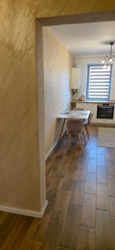 a dining room with a table and a kitchen at LCB Apartments Green Residence in Târgu-Mureş