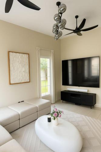a living room with a couch and a flat screen tv at Family Villa, Sleeps up to 9 in JVT and Large garden in Dubai