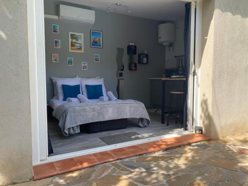 a bedroom with a bed with blue pillows at Studio de rêve au cœur du var. in Pourcieux