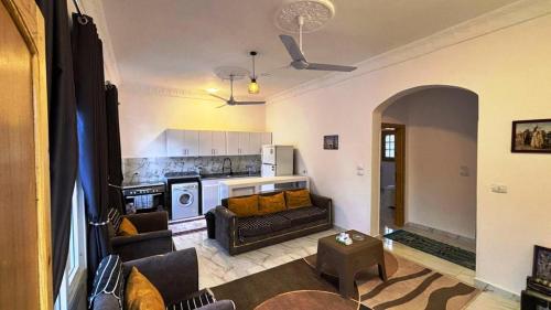 Una sala de estar con un sofá y una cocina. en Villa Hofni, en Luxor
