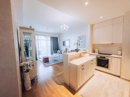 a kitchen with white cabinets and a living room at Beograd na vodi - BW ViSTA LUXURY in Belgrade