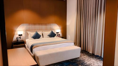 a bedroom with a large bed with blue pillows at Grand Day Hotel Boutique in Al Hofuf