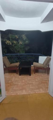 a room with two chairs and a table and a view at kishore villa in Mahabalipuram