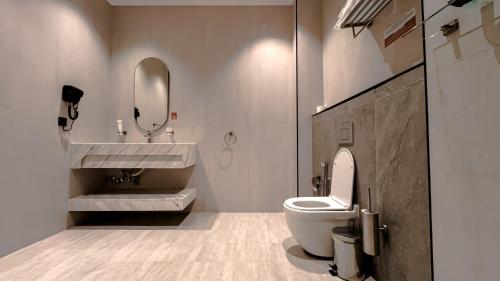 a bathroom with a toilet and a sink and a mirror at Grand Day Hotel Boutique in Al Hofuf