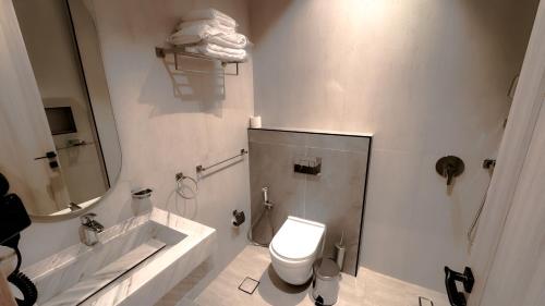 a bathroom with a toilet and a tub and a sink at Grand Day Hotel Boutique in Al Hofuf