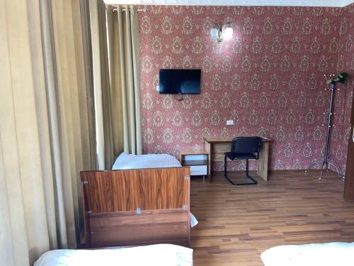 a room with a bedroom with a tv on a wall at Ziyo hotel in Yalanghoch