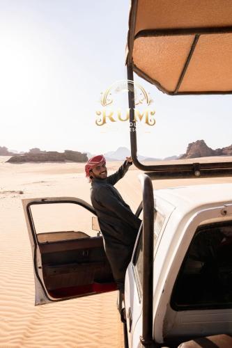 a man standing in the back of a vehicle in the desert at RUM GOLDEN DUNE lUXURY RESORT in Wadi Rum