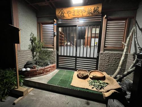 a front door of a house with a gate at やまきや旅館 in Uonuma