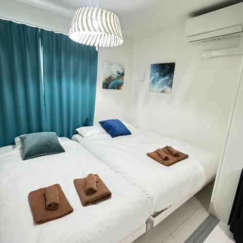 two beds in a room with towels on them at Palace Yokohama New & Private in Yokohama