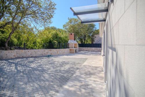 a building with a stone courtyard next to a wall at Summer Breeze in Gornji Humac