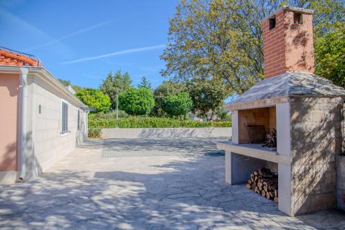 a brick oven in a yard next to a building at Summer Breeze in Gornji Humac