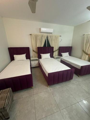 two beds in a room with two windows at Seaview Residency in Karachi