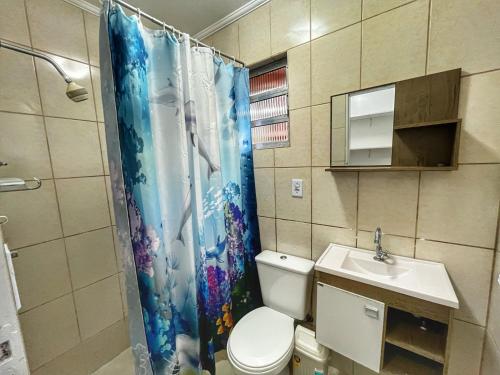 ein Badezimmer mit Toilette und Duschvorhang in der Unterkunft Experience House Maresias in São Sebastião