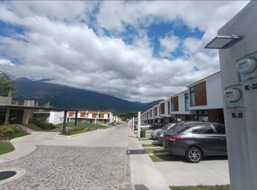 a street with cars parked on the side of a building at Kakaw's house, pool with a view of the 3 volcanoes in San Juan Alotenango