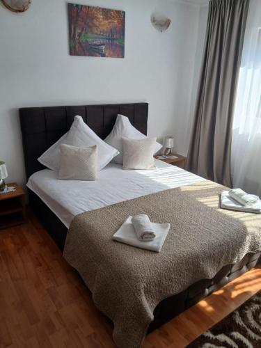 a bedroom with a bed with two towels on it at Casa Bogdan in Buşteni