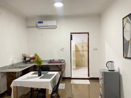 a kitchen with a table and a sink and a refrigerator at Zanzllywood Uroa Beach Apartments in Dikoni
