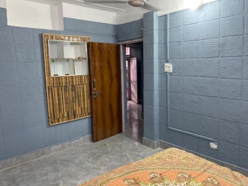 a room with a wooden door and a mirror at JIYA Guest HOUSE in Shāhpur