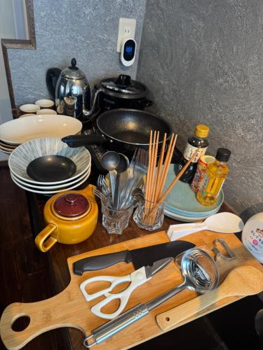 a wooden cutting board with utensils on a kitchen counter at 鵜飼とシャッター街 信長の山城に囲まれた岐阜の宿 2階フロア貸切 in Gifu