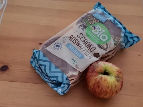 una bolsa de pan y una manzana sobre una mesa en Saarlouis, en Saarlouis