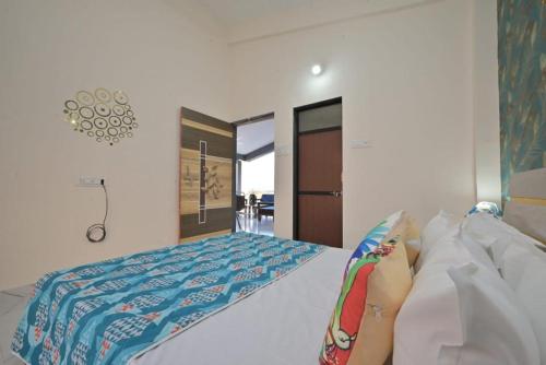 a bedroom with a bed with a blue comforter at ll EMPYREAN STAY ll LEONCINO VILLA ll 4BHK ll AC ll LONGEST PRIVATE POOL IN LONAVALA ll in Lonavala