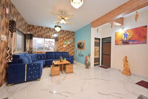 a living room with blue couches and a ceiling fan at ll EMPYREAN STAY ll LEONCINO VILLA ll 4BHK ll AC ll LONGEST PRIVATE POOL IN LONAVALA ll in Lonavala