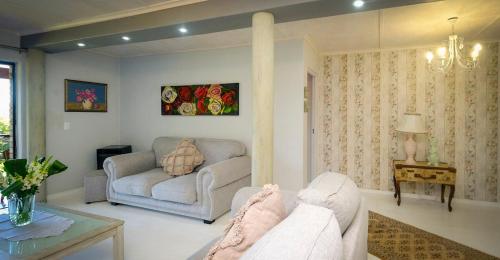 a living room with a couch and a table at 2BR Retreat Near Game Reserve in Gqeberha