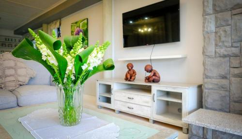 a vase of flowers on a table in a living room at 2BR Retreat Near Game Reserve in Gqeberha