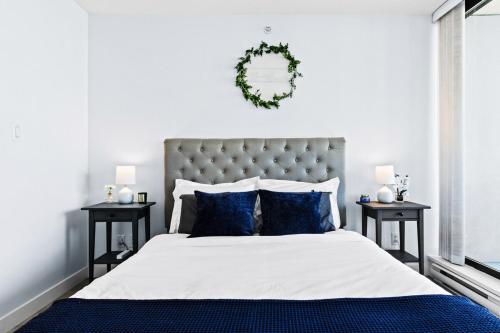 バーナビーにあるArcola Retreat, Modern Condo with Balcony, Workspace and Viewsの青い枕が付いた大きなベッドのある寝室