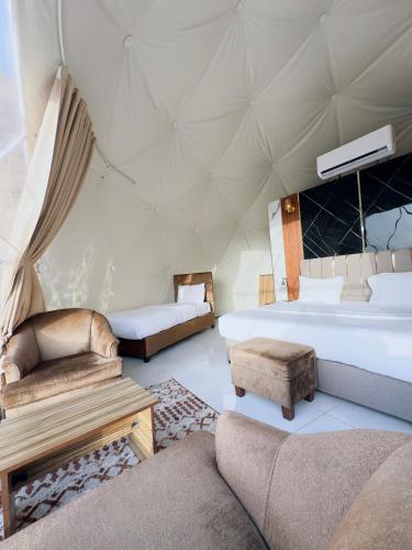 ein Zimmer mit einem Bett und einer Couch in einem Zelt in der Unterkunft domes wadi Rum in Wadi Rum