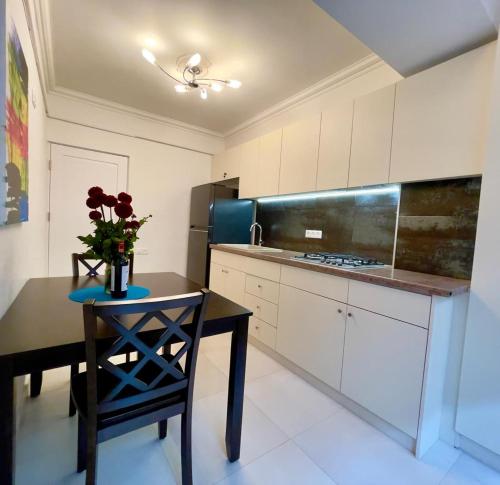 Una cocina con una mesa con un jarrón de flores encima. en Sweet 56, en Ereván