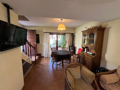 a living room with a dining room table and a television at Dúplex Del mar, ideal para descansar en familia - Ayres del Bosque Alojamientos in Pinamar