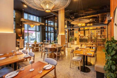 a restaurant with wooden tables and chairs and windows at Tokapa, a place between worlds in Cape Town