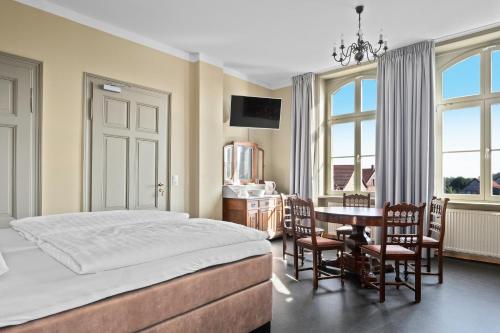 a bedroom with a bed and a table and chairs at Villa Bianca am Huy in Dingelstedt
