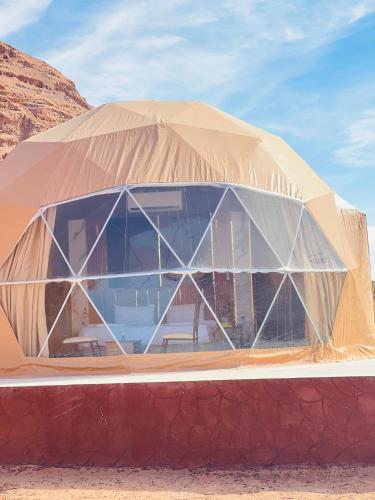 ein Kuppelgebäude mit einem großen Glasfenster in der Unterkunft domes wadi Rum in Wadi Rum