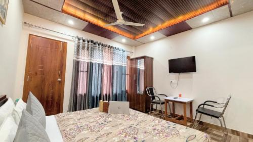 a bedroom with a bed with a laptop on it at Royal Green Valley Kasauli in Kasauli