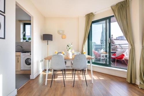 a dining room with a table and chairs and a window at BnBNova - Tower Bridge - 1BR - St Paul's in London