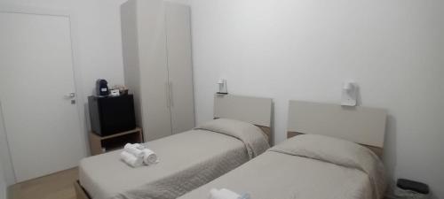 a room with two beds with towels on them at Riccabea in Alghero