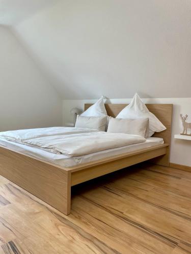 a bedroom with a bed with white sheets and pillows at Haus87a in Oberkirch