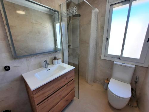 a bathroom with a sink and a toilet and a window at Apartment Del Sol with SEA views in Salou
