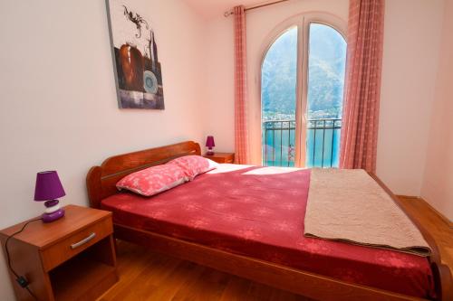 a bedroom with a bed and a large window at Apartments Panorama in Kotor