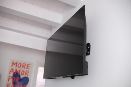 a flat screen tv hanging on a wall at Cortile San Luigi in Capo dʼOrlando