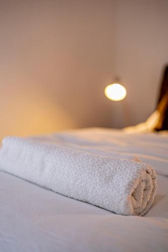 a white towel laying on top of a bed at La Villa des Pins - Appartement Alep in Lope