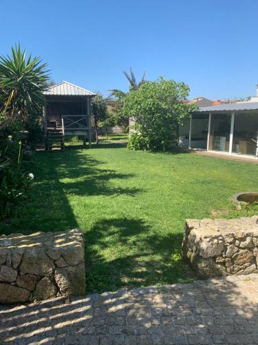 a yard with green grass and a building at Beach house Estrela do Mar in Vila Chã