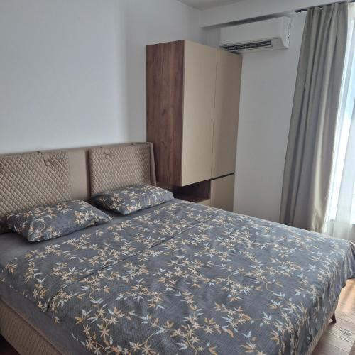 una camera da letto con un letto con un piumone blu di V i N Boutique Apartment a Niš