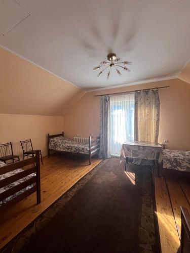 a room with two beds and a ceiling fan at Smerichka in Zagorody