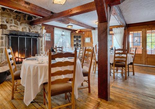 a dining room with a table and chairs and a fireplace at Auberge Handfield et Spa in Saint-Marc-sur-Richelieu